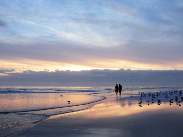 Retired couple walking on beach